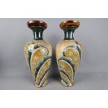Doulton Lambeth - A pair of stoneware vases of baluster form with stylised floral and 'feather'