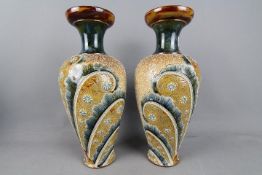 Doulton Lambeth - A pair of stoneware vases of baluster form with stylised floral and 'feather'