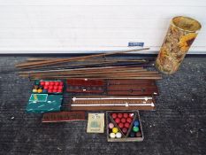 A collection of snooker cues, scoreboards, snooker balls, cue rack and similar.