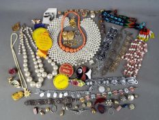 A mixed lot of costume jewellery to include an enamelled silver .