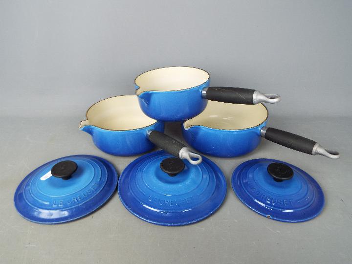 Le Creuset - A set of three cast iron Le Creuset pans in blue with lids marked 16, 18,