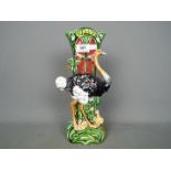 A late 19th / early 20th century majolica vase with ostrich figure and floral decoration,