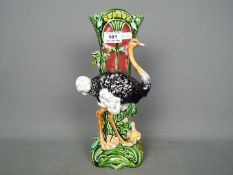 A late 19th / early 20th century majolica vase with ostrich figure and floral decoration,