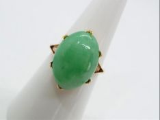 A yellow metal unmarked dress ring (presumed 14k) with cabochon jade stone measuring 1.