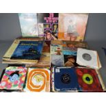 A collection of 7" and 12" vinyl records to include The Beach Boys, Deep Purple, The Beatles,