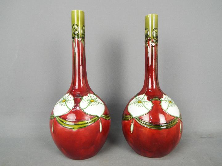 A pair of Minton Secessionist vases of slender necked, bottle form,