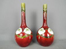 A pair of Minton Secessionist vases of slender necked, bottle form,