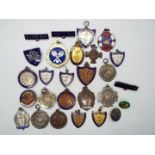 A collection of sporting medals and badges including four hallmarked silver examples