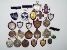 A collection of sporting medals and badges including four hallmarked silver examples
