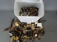 A large quantity of watch parts including movements, lenses, cases, bracelets and similar.