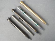 Five propelling pencils comprising an Eversharp rolled gold, a Platignum, a silver plated example,
