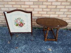 An Oak fire screen with an embroidered tapestry panel and glass front plus a small solid wood drop