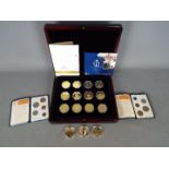 A case containing twelve gold plated commemorative crowns including Elizabeth II 80th birthday