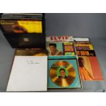 A collection of 12" vinyl records to include Elvis, Rod Stewart, The Carpenters, Motown and similar,