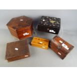 A collection of five wooden storage / trinket boxes of varying size and form.