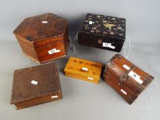 A collection of five wooden storage / trinket boxes of varying size and form.