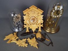 Two anniversary clocks and a cuckoo clock with pendulum and one weight.