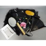 An ebony dressing table set comprising mirror and two brushes, a paper fan,