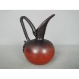 A Schneider glass ewer, dark red, etched signature, approximately 15.5 cm (h).