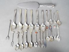 A collection of flatware to include silver handled cake slice, a quantity of spoons,