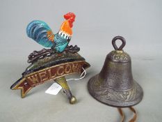 A cast iron welcome sign with attached bell, surmounted with cockerel.