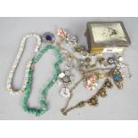 A small metal box and contents of assorted costume jewellery,