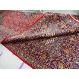 A large red ground Persian Kashan carpet measuring approximately 290 cm x 400 cm