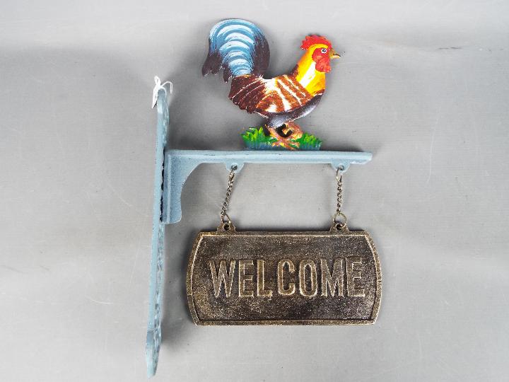 A cast iron, cockerel, welcome sign.