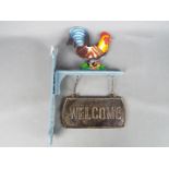 A cast iron, cockerel, welcome sign.