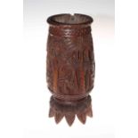 South Sea carved wood vase decorated with palm trees and on multiple head feet, 28cm.