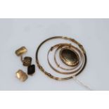 Gold jewellery including bangle and locket.