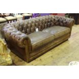 Brown deep buttoned distressed leather three seater Chesterfield settee.