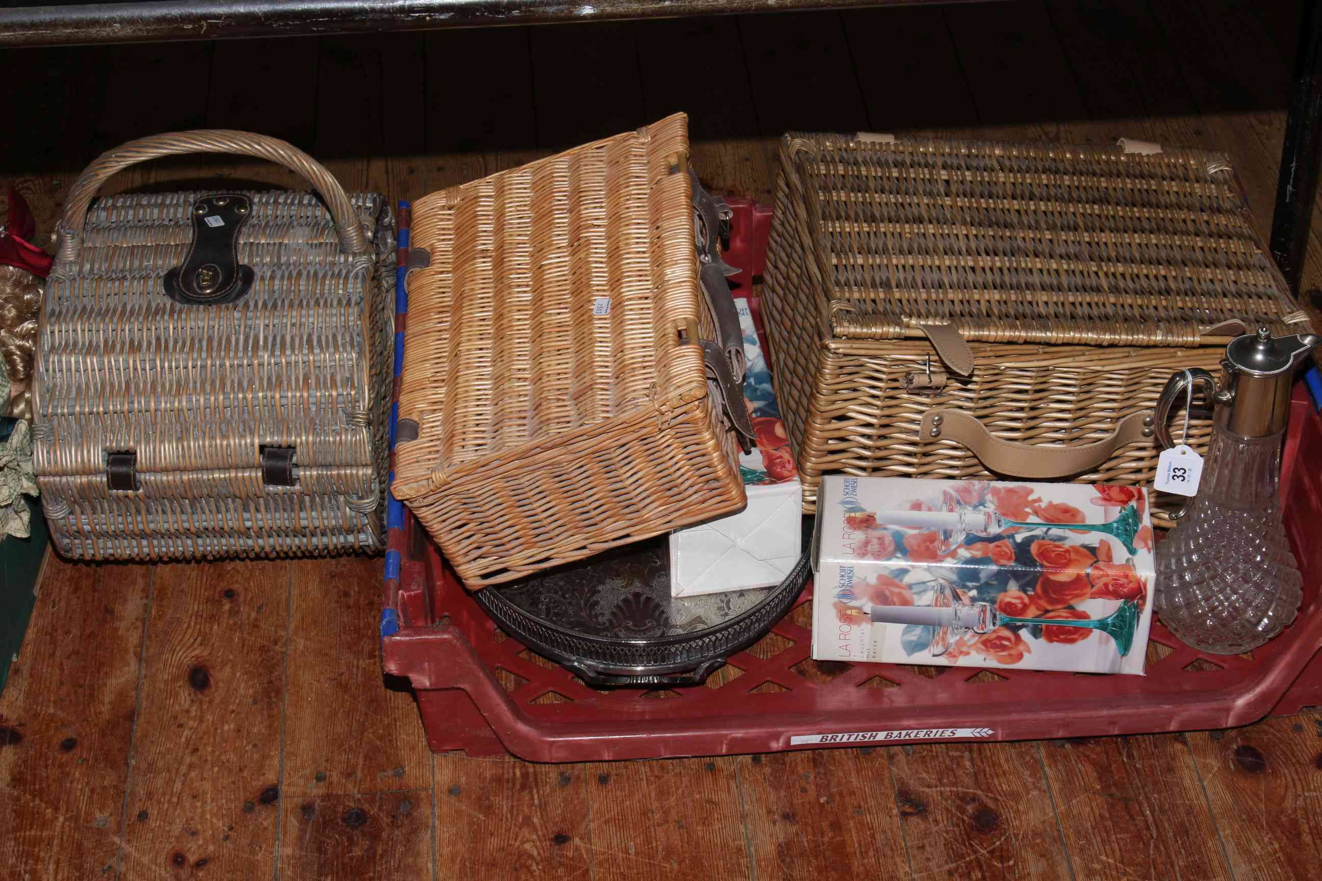 Three wicker picnic baskets, glass claret jug,