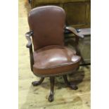 Early 20th Century hide and studded swivel office open armchair on ball and claw feet.
