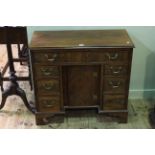 19th Century mahogany seven drawer desk with inset cupboard door on shaped bracket feet,