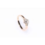 Three stone diamond ring set in 14K gold, having cushion shaped stone flanked by brilliants.