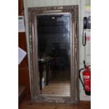 Large rectangular bevelled wall mirror in ornate silvered frame, 177cm by 89cm overall.