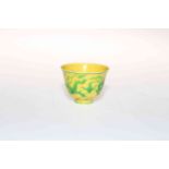 Small Chinese yellow glaze cup decorated with dragons, six character mark to base, 4.5cm high.