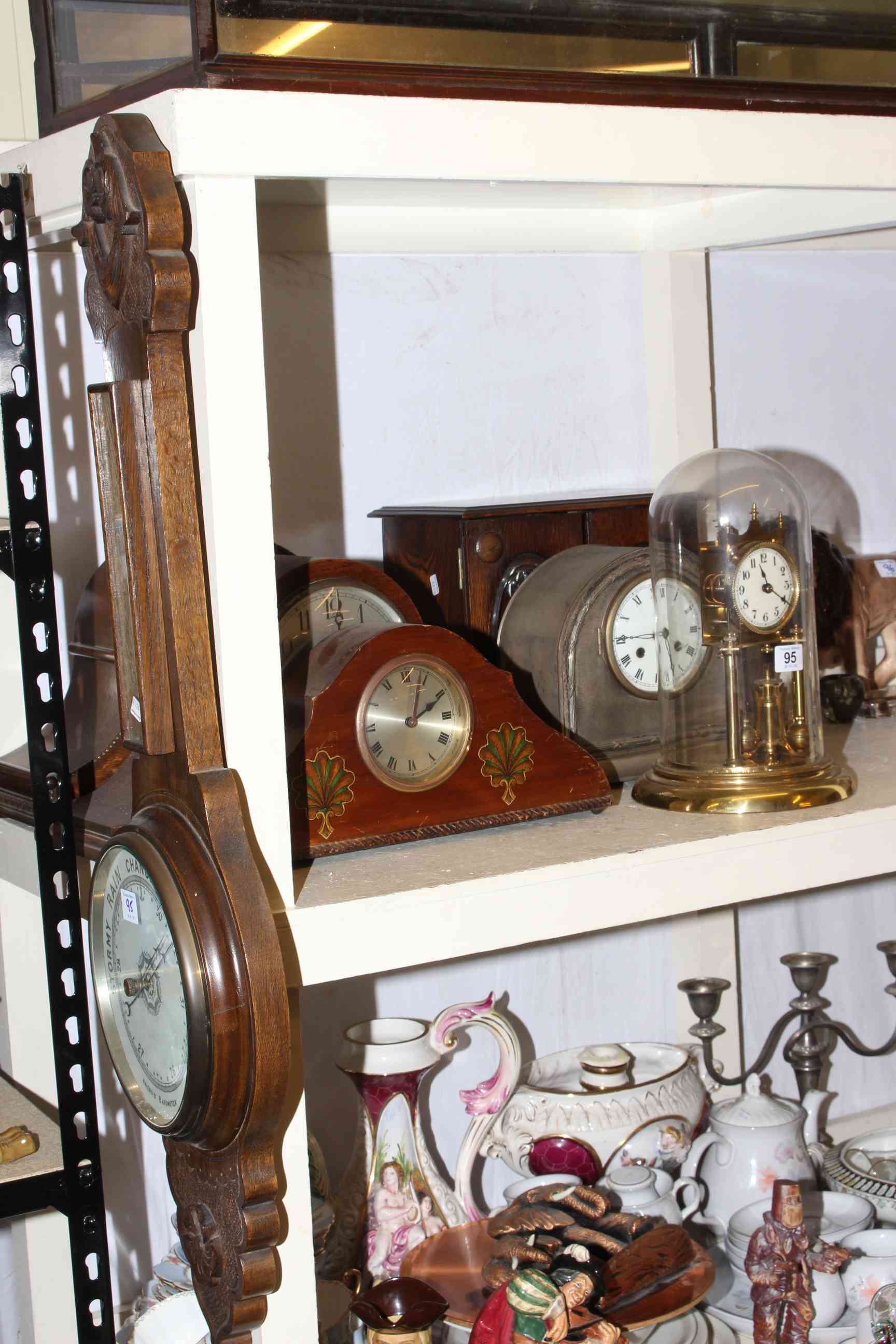 Collection of mantel clocks, barometer, carriage clock with dome and a wooden cabinet with drawers.