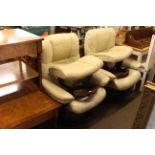 Pair Stressless ivory leather adjustable swivel chairs and footstools.