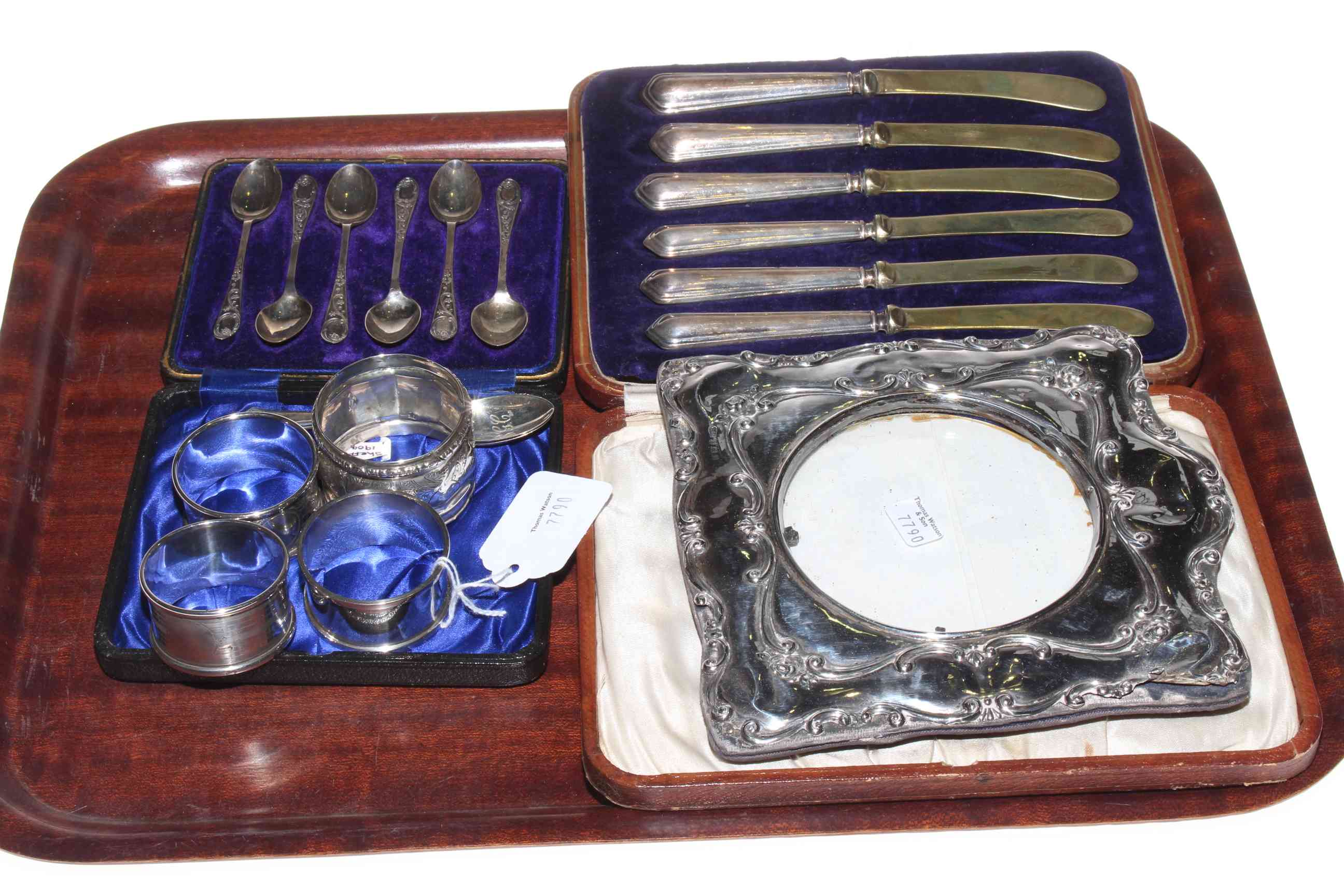 Silver photograph frame, cased silver spoons, silver handled knives and four silver napkin rings.