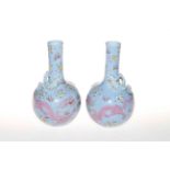 Pair Chinese bottle vases with relief, painted and enamelled dragon decoration on blue ground,
