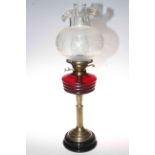 Brass column oil lamp with ruby glass reservoir and etched and frosted shade.