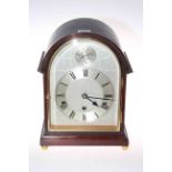 Mahogany mantel clock with quarter striking movement, of arched shape and on brass ball feet, 32cm.