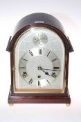 Mahogany mantel clock with quarter striking movement, of arched shape and on brass ball feet, 32cm.