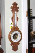 Carved oak barometer with enamelled dial.