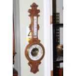 Carved oak barometer with enamelled dial.