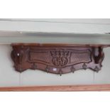 Carved oak seven hook coat rack, 109cm long.