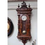 Vienna wall clock in walnut with keyhole pendulum winder, half columns and ornate pediment,