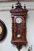 Vienna wall clock in walnut with keyhole pendulum winder, half columns and ornate pediment,